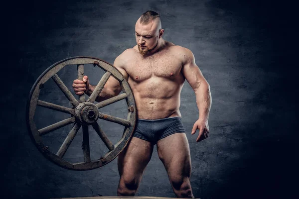Shirtless man houdt houten wiel — Stockfoto