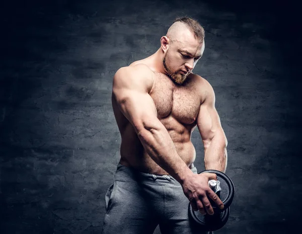 Shirtless bodybuilder holds dumbbell — Stock Photo, Image