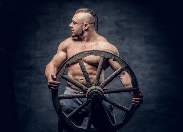 Hunk man holds holds wooden wheel