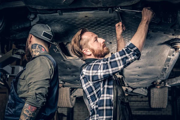 Dos mecánicos trabajando en garaje —  Fotos de Stock