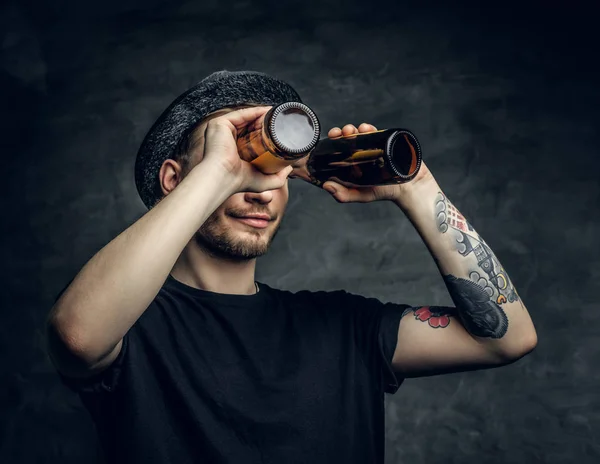 Человек смотрит через две пивные бутылки — стоковое фото