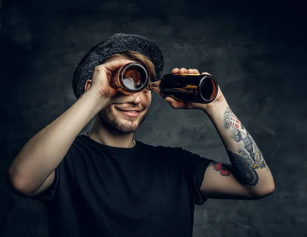 Man looking through two beer bottles — Stock Photo, Image