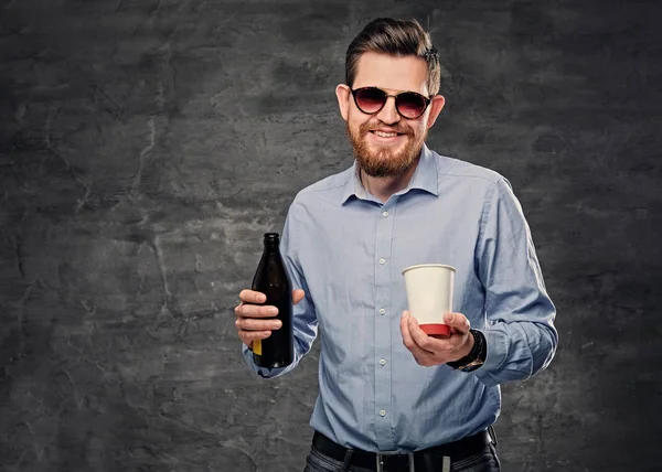 Мужчина держит бумажную чашку и пиво — стоковое фото