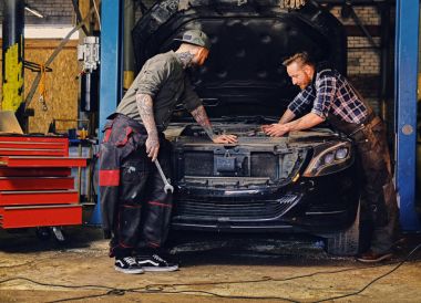 Two mechanics fixing car's engine clipart