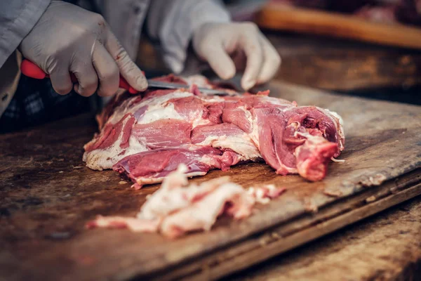 Человек режет свежее мясо свинины . — стоковое фото