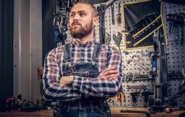 Bisiklet tamircisi çapraz kolları olan sakallı