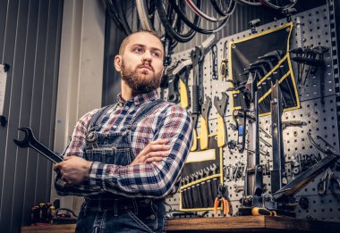 Tamirci anahtarı aracı sandalyesinden tutar. 