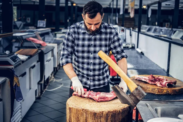 Açougueiro barbudo corta carne fresca — Fotografia de Stock
