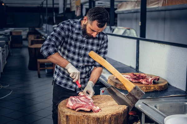 Açougueiro barbudo cortando bacon fresco — Fotografia de Stock