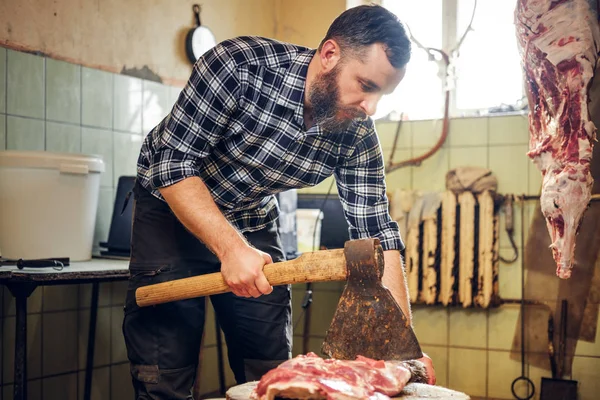 Butcher cuts meat with axe — Stock Photo, Image