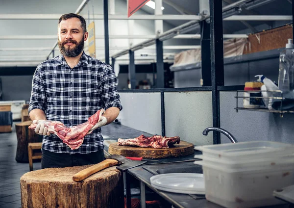 Bearded butcher holds meat
