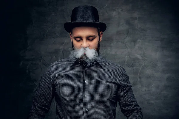 Бородатый мужчина курит электронную сигарету — стоковое фото