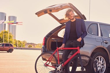 Adam araba yakınındaki sabit bisiklet ile 