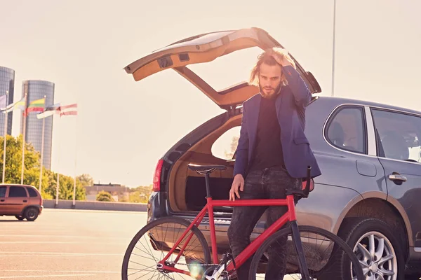 Hombre con bicicleta fija cerca del coche — Foto de Stock