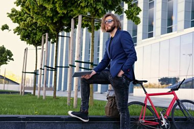 Tablet ve bisiklet ile ayakta adam 