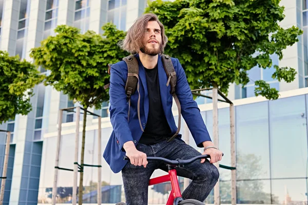 Hombre con mochila en bicicleta fija — Foto de Stock