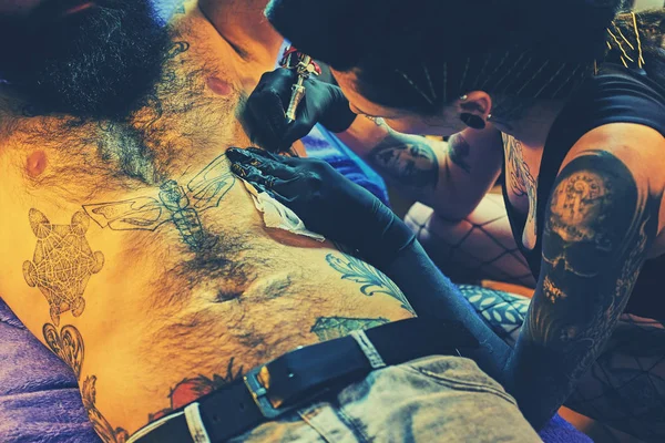 Una artista profesional del tatuaje femenino — Foto de Stock