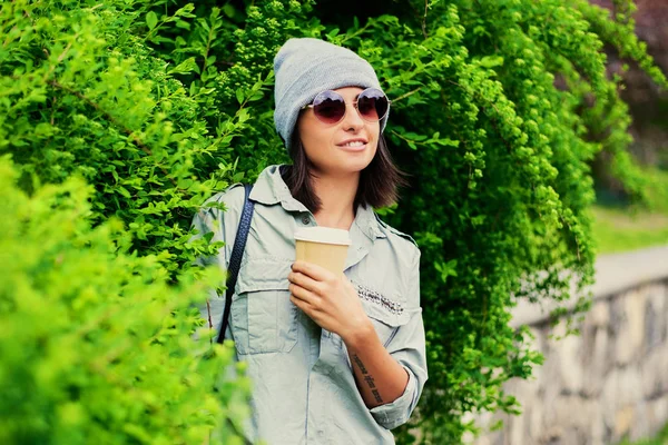 Frau mit Sonnenbrille hält Kaffeetasse aus Papier — Stockfoto