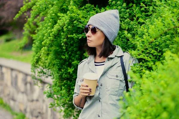 Frau mit Sonnenbrille hält Kaffeetasse aus Papier — Stockfoto