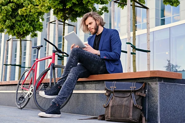 Man with long hair using tablet