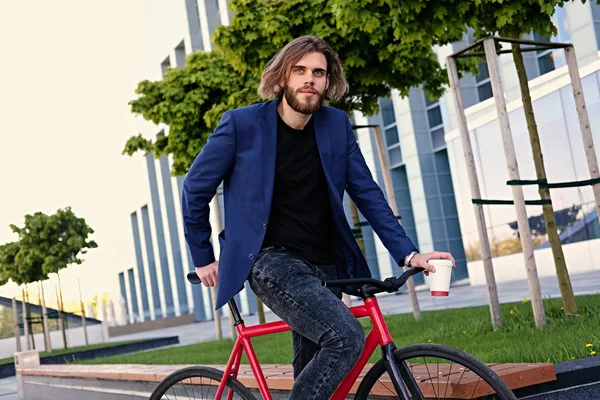 El hombre se sienta en la bicicleta fija roja — Foto de Stock