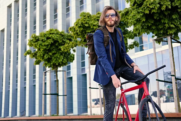 El hombre se sienta en la bicicleta fija roja — Foto de Stock