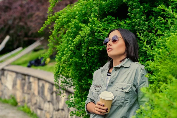 Brunett kvinnlig solglasögon dricker kaffe — Stockfoto