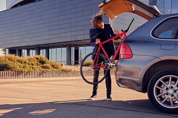 Hombre poniendo bicicleta fija en el coche — Foto de Stock