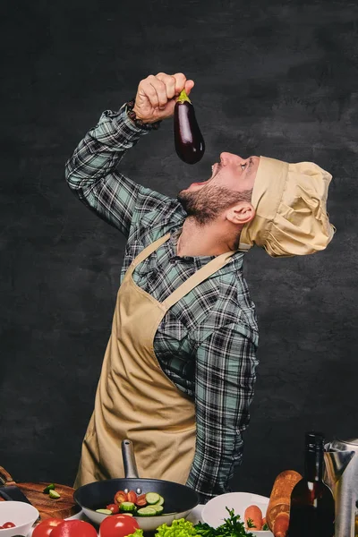 Chef-kok eet aubergine — Stockfoto