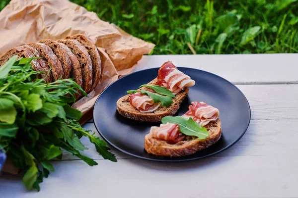 Brood met ham en kruiden op een plaat. — Stockfoto