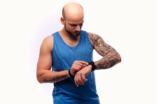 Musculoso hombre viendo en su reloj inteligente —  Fotos de Stock
