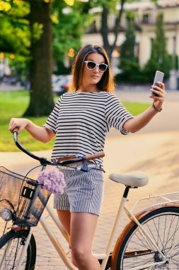 Bir bisiklet üzerinde bir parkta esmer kadın