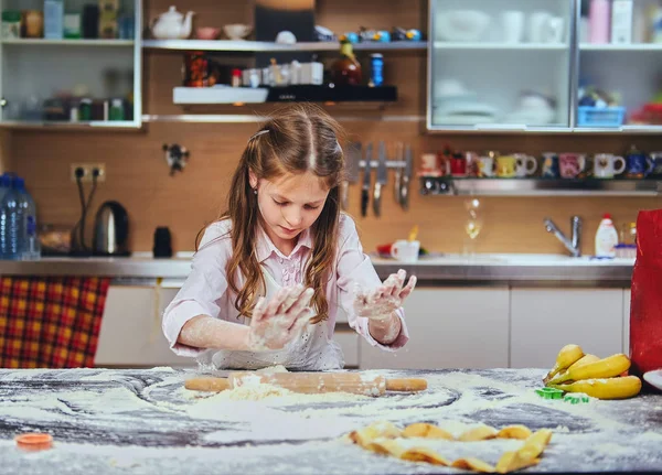 Fröhliches kleines Mädchen kocht — Stockfoto