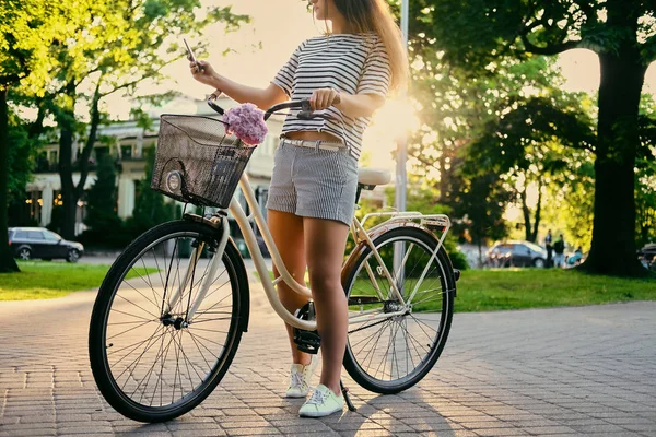 Bir bisiklet üzerinde bir parkta esmer kadın