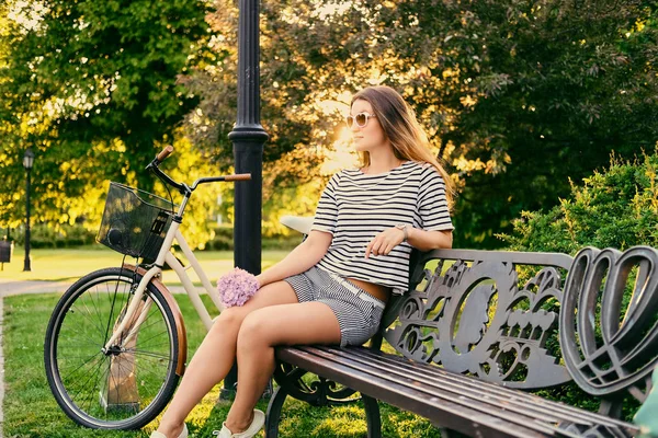 Brünette Frau sitzt auf einer Bank — Stockfoto