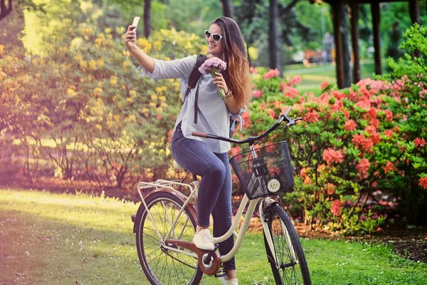 Женщина на велосипеде делает селфи — стоковое фото