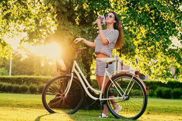 Frau hält Blumenstrauß in der Nähe von Stadtrad — Stockfoto