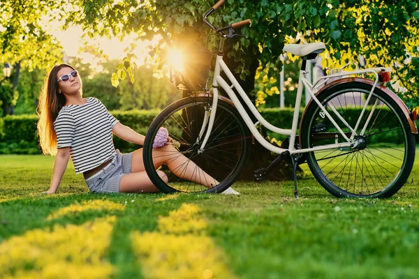 Weibchen sitzt auf einer Liegewiese im sonnigen Park — Stockfoto