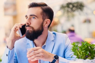 Akıllı telefon kullanan sakallı adam portresi.