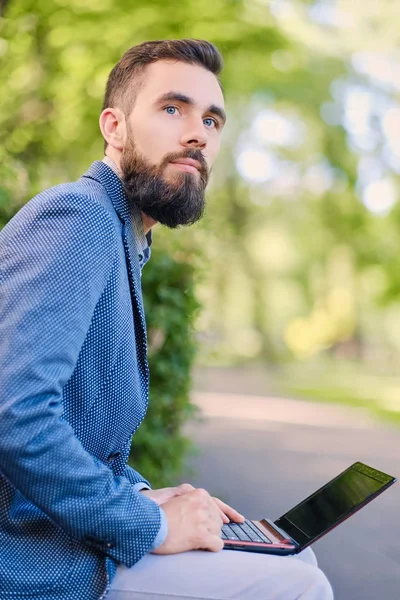 Άνθρωπος χρησιμοποιώντας φορητό υπολογιστή σε ένα πάρκο — Φωτογραφία Αρχείου