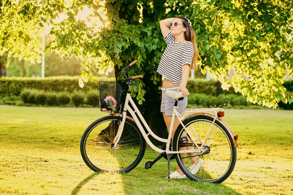 Morena mujer con bicicleta de ciudad — Foto de Stock