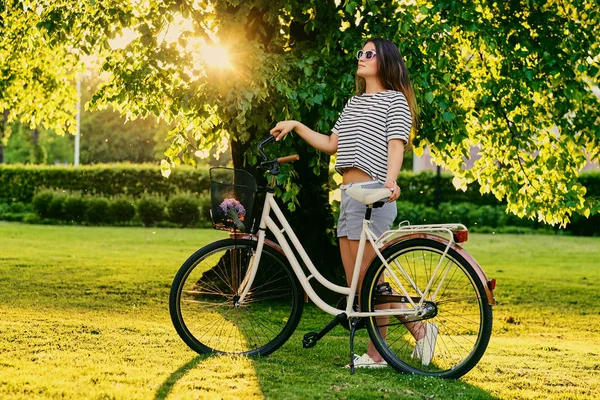 Morena mujer con bicicleta de ciudad — Foto de Stock