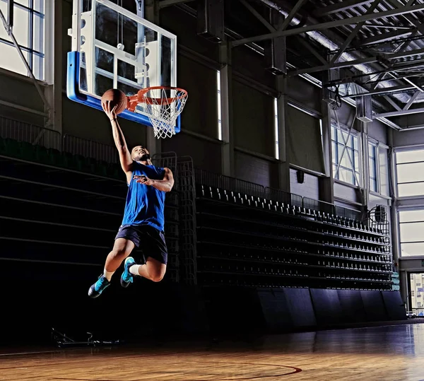 Jogador de basquete em ação em um campo de basquete — Fotografia de Stock