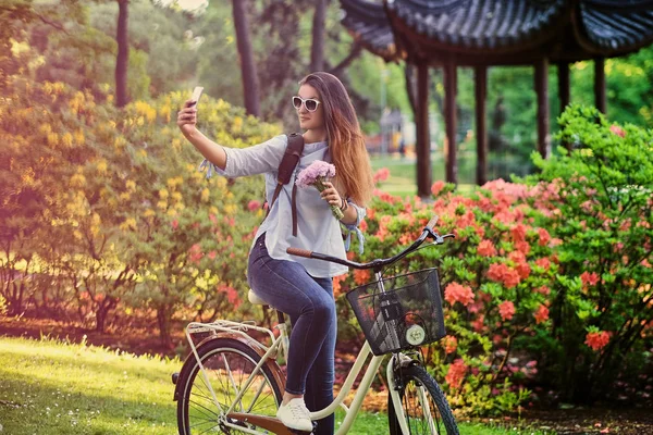 Feminino em uma bicicleta fazendo selfie — Fotografia de Stock