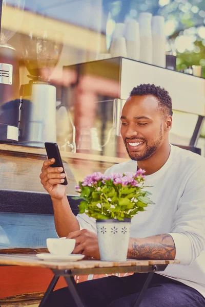 Человек, использующий смартфон в кафе — стоковое фото