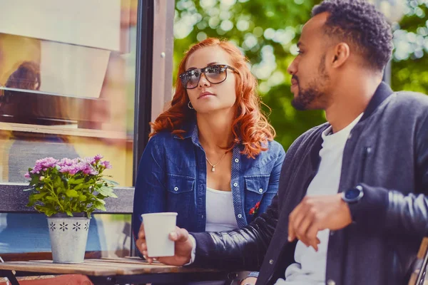 Черный мужчина и рыжая женщина в кафе — стоковое фото