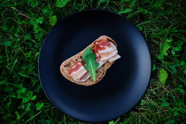 Jambon ve bir plaka üzerinde otlar ile ekmek.