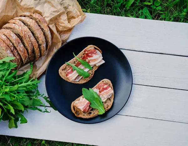 Brood met ham en kruiden op een plaat. — Stockfoto