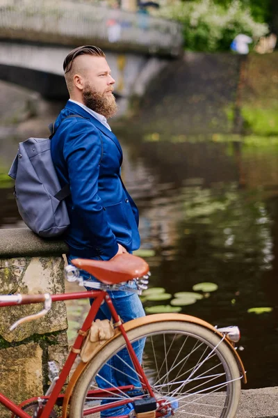 Bearded male in a blue jacket and bicycle