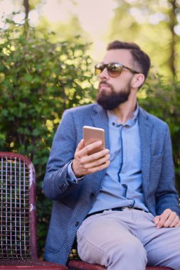 Akıllı telefon kullanan şık sakallı adam